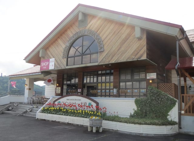 ワインシャトー大迫の外観。木造の三角屋根の建物とチューリップの花壇