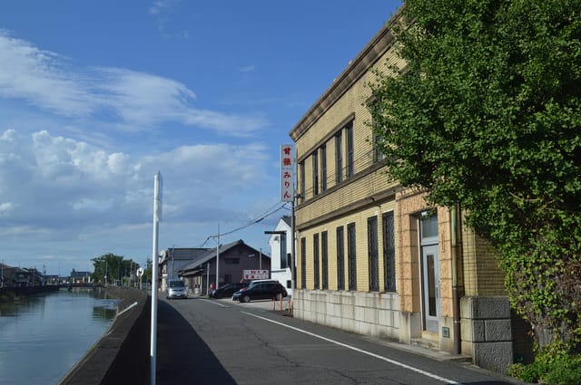 蟹江川沿いに建つ甘強酒造の外観